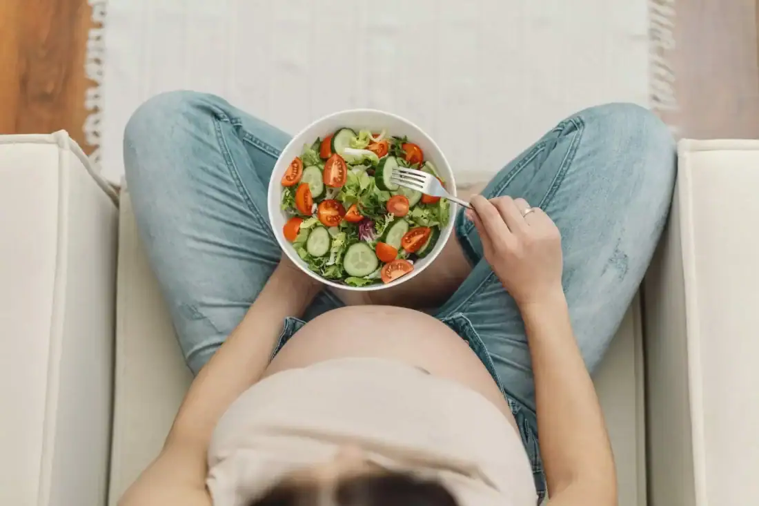 Healthy woman eats salad with vegetables and cucumber, nutritional advice for wellbeing.