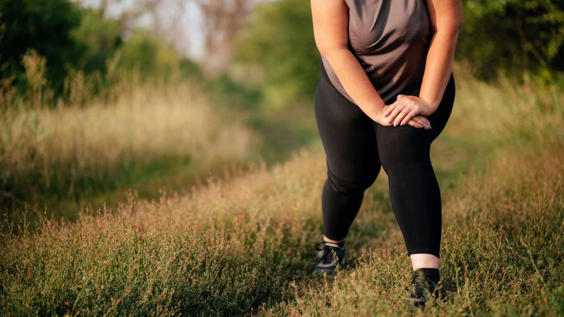 Overweight and weight loss, woman in sportswear in nature setting.
