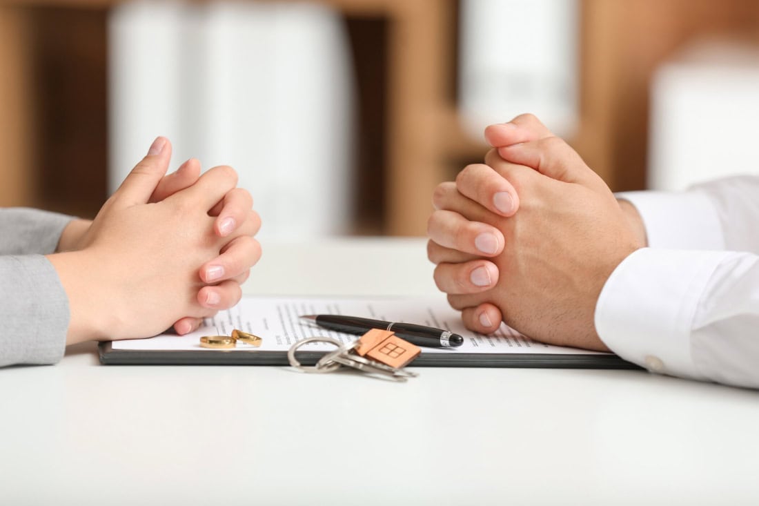 A divorce negotiation with two people holding hands.